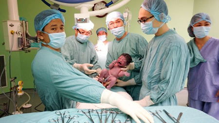 Ê-kíp các y - bác sĩ tại Bệnh viện T.Ư Huế thực hiện thành công ca mang thai hộ đầu tiên và cháu bé chào đời lúc 8 giờ 10 phút sáng nay, 28-7 (ảnh do GS Bùi Đức Phú cung cấp).